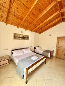 a bedroom with two beds and a wooden ceiling at Magnus Appartments in Dukat