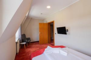 a bedroom with a bed and a tv on the wall at Hotel Lengenfelder Hof in Lengenfeld