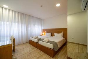 a bedroom with a large bed in a room at Central Suítes 1 in São João da Madeira