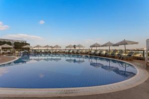 a large swimming pool with umbrellas on a resort at Novotel Abu Dhabi Gate in Abu Dhabi