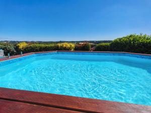 a large blue swimming pool with a wooden deck at une nuit insolite en 1980 in Crédin