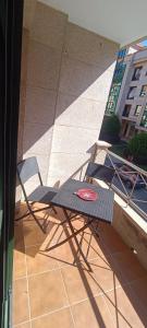 two chairs and a table on a balcony at Calle Maceiras, 1 - 1B in Combarro