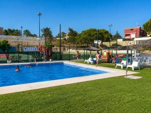 a swimming pool in a park with people playing in it at YOKOI La Antilla in La Antilla