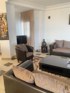 a living room with a couch chair and a table at Immeuble Mohamet Mbacké TAÏF in Dakar