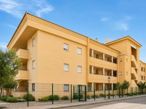 a yellow building with a fence in front of it at YOKOI La Antilla in La Antilla