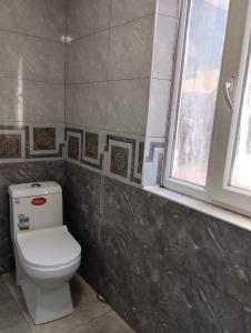 a bathroom with a toilet and a window at Entire 4th Floor for Guests in Batumi