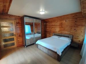 a bedroom with a bed in a wooden room at Entire 4th Floor for Guests in Batumi