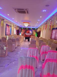a banquet hall with rows of chairs and a stage at Vaidehi Inn-A Unit of vaidehi guest house in Deoghar