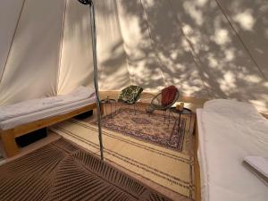 a tent on a boat with a bed and a rug at Glamping by the sea in Äggrund