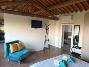 a room with a bed and a chair and a television at Casa vacanze Conca d Oro in SantʼAmbrogio di Valpolicella