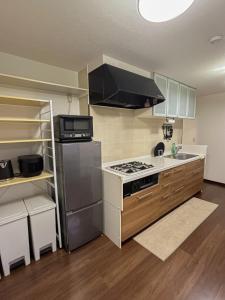 a kitchen with a refrigerator and a stove top oven at COMMA House 川崎 in Kawasaki +41 photos