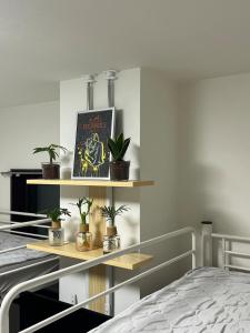 a bedroom with a bed and shelves with plants at COMMA House 川崎 in Kawasaki