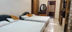 two beds sitting in a room with a mirror at Prithviraj palace in Shahdol