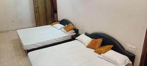 two twin beds in a room with at Prithviraj palace in Shahdol +4 photos