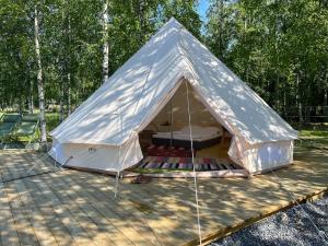 a white tent sitting on top of a wooden deck at Glamping by the sea in Äggrund