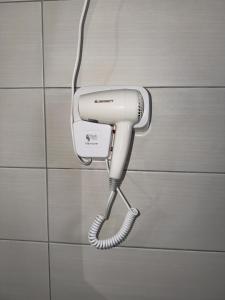 a white hairdryer hanging on a wall at Blue Shore in Golem