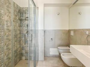 a bathroom with a toilet and a glass shower at Miramare Suites in Vasto