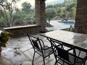 a patio with a table and chairs and a pool at Alpujarra Las Lindes in Pórtugos