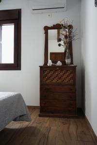 a bedroom with a dresser with a mirror on it at Alpujarra Las Lindes in Pórtugos +11 photos