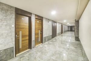 a hallway with wooden doors and tile walls at Hotel O New Pride in Sāngli +75 photos