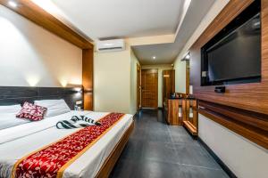 a bedroom with a bed and a flat screen tv at Abirami Residency in Pondicherry