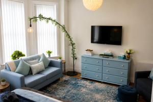 a living room with a blue couch and a dresser at Lavina by the sea in Bangor