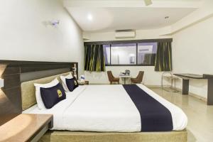 a bedroom with a large bed and a table at Hotel O New Pride in Sāngli