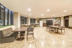 a large room with tables and chairs and a couch at Hotel O New Pride in Sāngli