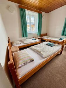 three bunk beds in a room with green curtains at Ubytování Přimda in Přimda