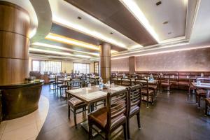 a restaurant with tables and chairs and a bar at Abirami Residency in Pondicherry