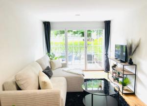 a living room with a couch and a glass table at Appartement "Suite Seeliebe" in Tägerwilen