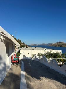 two red chairs sitting on the side of a building at Hector -Sweet home with a beautiful view in Agia Marina +7 photos