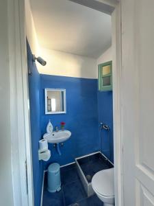 a blue bathroom with a sink and a toilet at Hector -Sweet home with a beautiful view in Agia Marina