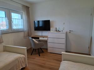 a bedroom with a desk with a computer and a television at Ferienhaus Zerbst in Zerbst