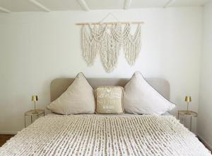 a bedroom with a bed with white pillows and a chandelier at Appartement "Suite Seeliebe" in Tägerwilen