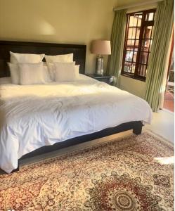 a bedroom with a large white bed and a rug at Executive Serviced Home in Johannesburg