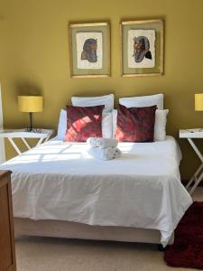 a bedroom with a large white bed with red pillows at Executive Serviced Home in Johannesburg +16 photos