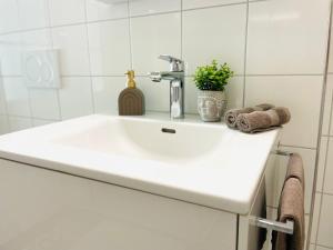 a white bathroom sink with a faucet and towels at Appartement "Suite Seeliebe" in Tägerwilen +10 photos
