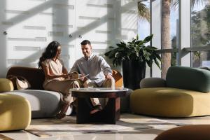 a man and a woman sitting in a living room at Novotel Abu Dhabi Gate in Abu Dhabi +75 photos