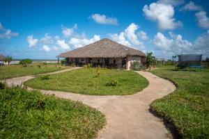a path leading to a hut on the beach at HOTEL H1 MANANJARY in Mananjary