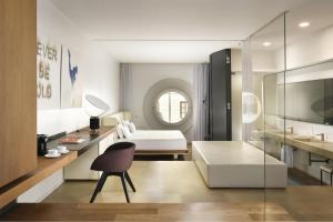 a large white room with a bed and a chair at Palazzo Montemartini Rome, A Radisson Collection Hotel in Rome +126 photos