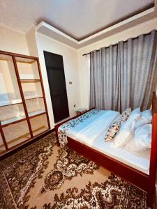 a bedroom with a large bed with a window at Makali Private Villa- 2En-Suite Bedrooms in Arusha