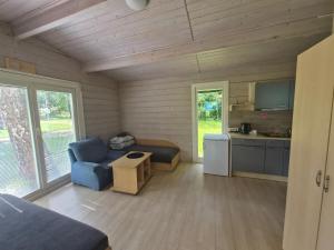 a living room with a blue couch and a kitchen at Giruliu kopa in Melnragė +22 photos