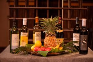 a basket of fruit with bottles of wine and a pineapple at HOTEL H1 MANANJARY in Mananjary