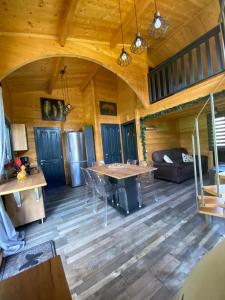 an open living room with a table in a cabin at Mon chalet dans le Jura in Saint-Laurent-en-Grandvaux
