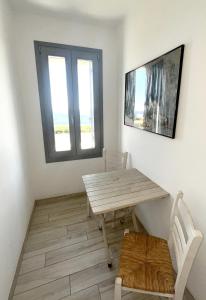 a table and chairs in a room with a window at Rosalie Home - Open Sea Duo in Tinos
