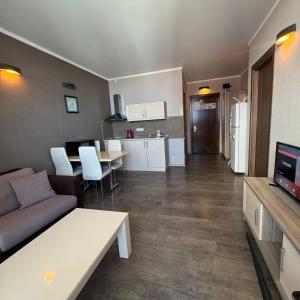 a living room with a couch and a table and a kitchen at Selfie in Batumi