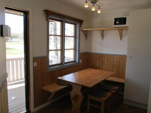a room with a wooden table and a window at Klarälvens Camping in Stöllet