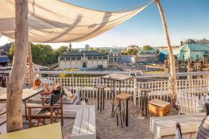 a person sitting at a table on the roof of a building at Staycity Aparthotels Dresden City Centre in Dresden