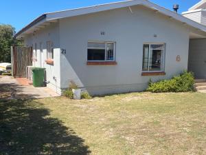 a white house with a green trash can in front of it at lagoon value ! in Langebaan